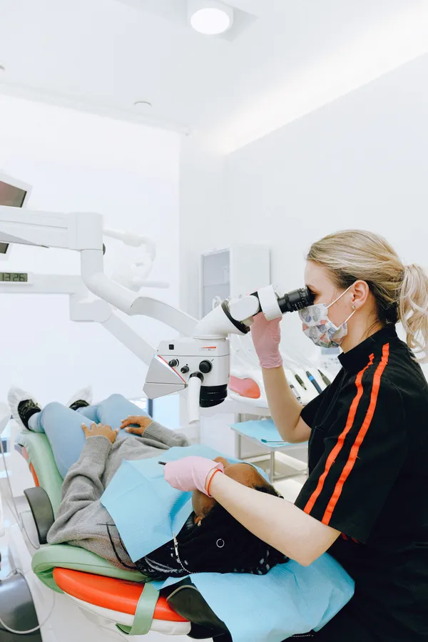 Maya Lindqvist checking a patient's teeth through a dental microscope